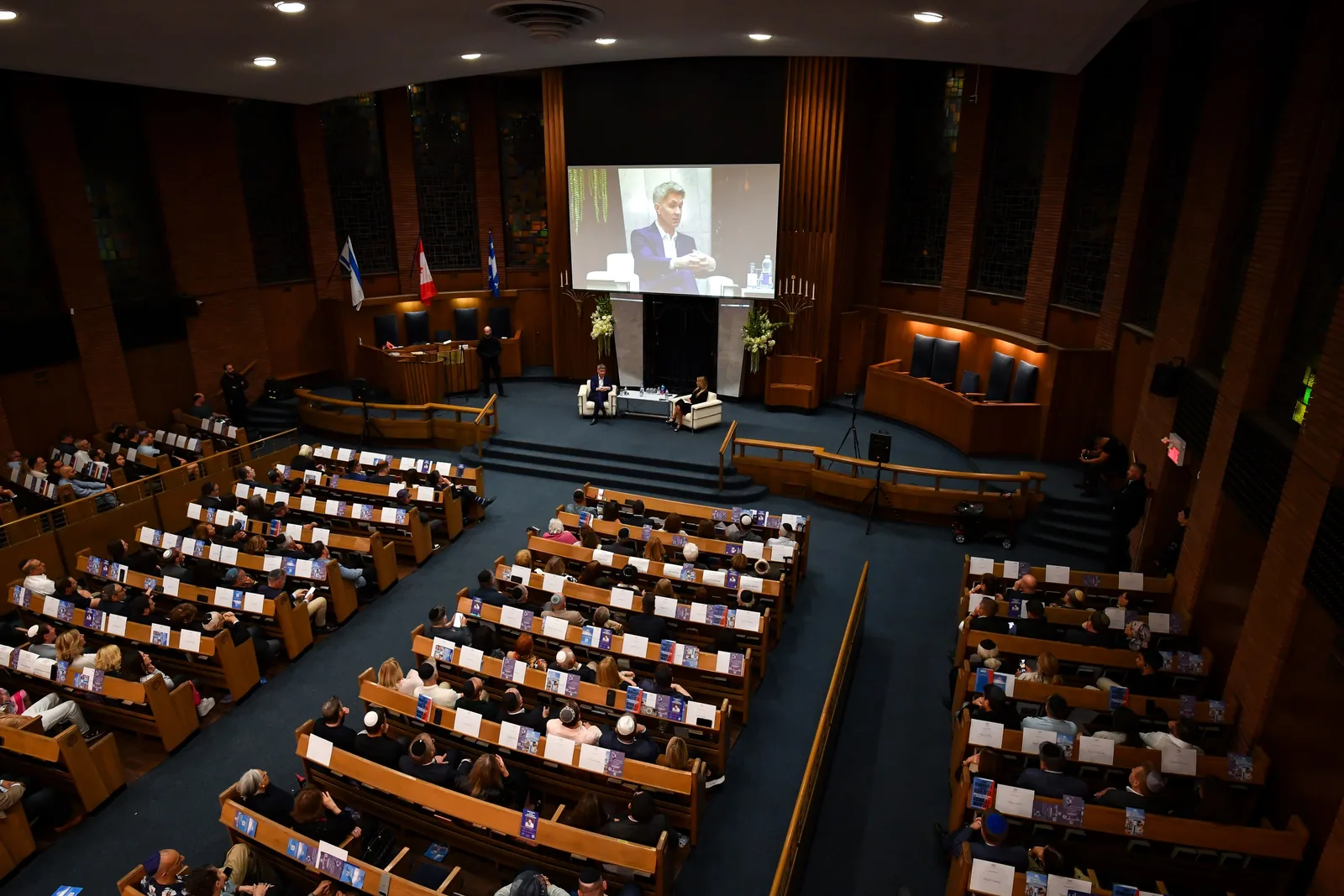Looking down from the balcony at a full sanctuary listening to a conversation on the stage