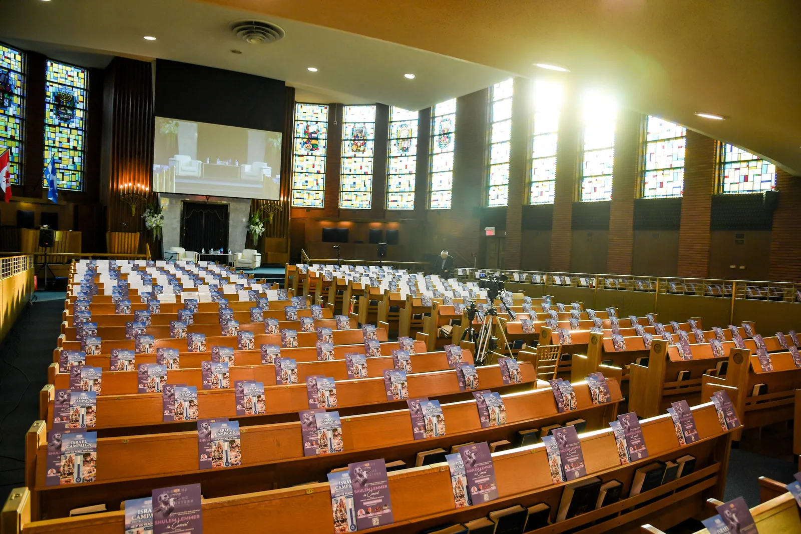 The empty sanctuary in the late-afternoon sun: light pouring through the tall stained-glass windows, a printed program on every pew, the ark at the far end